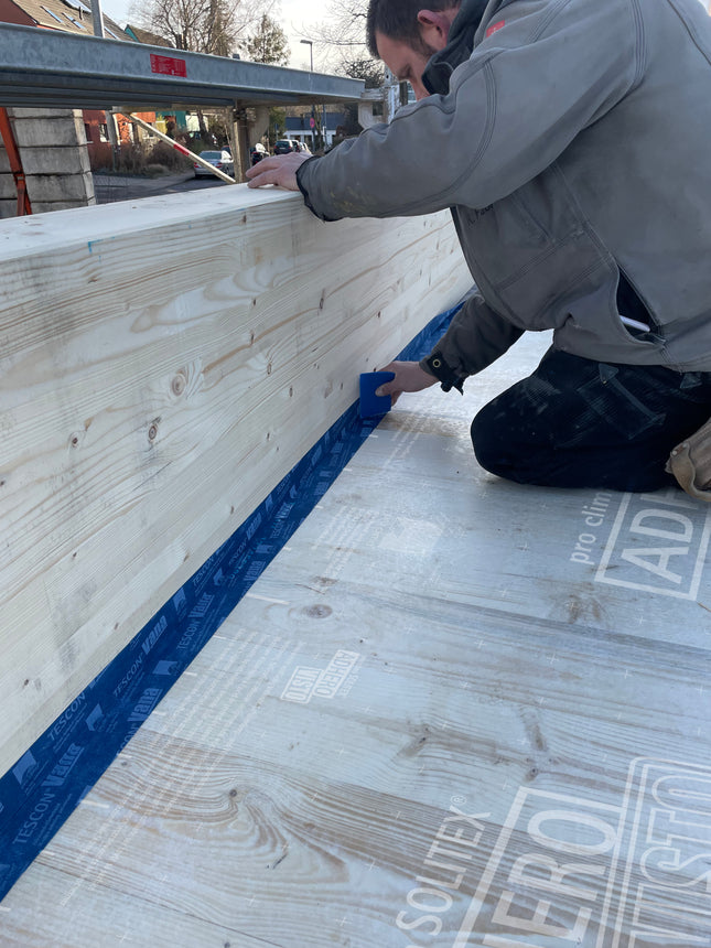 Pro Clima SOLITEX ADHERO VISTO átlátszó fólia ragasztása födémre: párfékező lég- és vízzáró védelem látható alapfelület mellett az építés alatt.