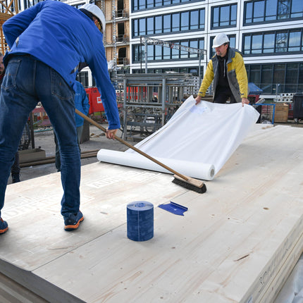 Pro Clima SOLITEX ADHERO VISTO öntapadó fólia simítása seprűvel CLT panelen: a légzáró réteg buborékmentes, szakszerű rögzítése.